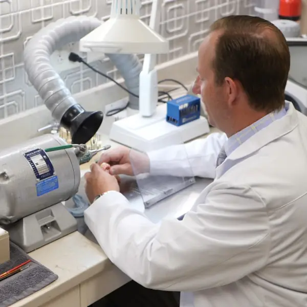 Prosthodontist fine tuning an upper arch for all on four dental implants in his lab